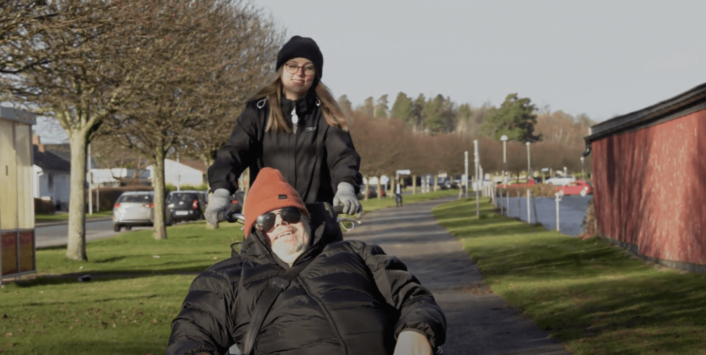 Kund som ler ute i solskenet och personlig assistent